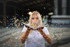 image of a woman blowing confetti off a book